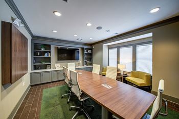 a conference room with a long wooden table and yellow chairs  at Avellan Springs Apartments, Morrisville, NC